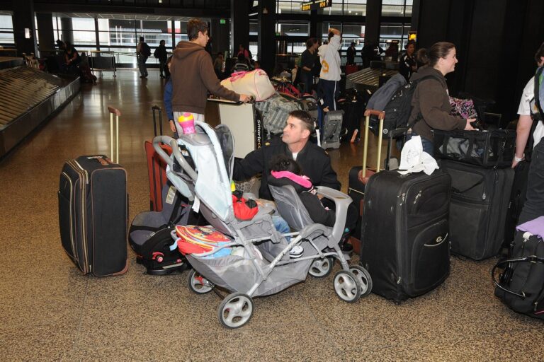 Kleiner bunter Kinderkoffer steht neben einem großen Reisekoffer