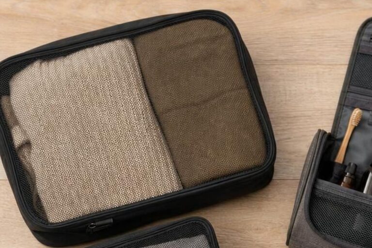 Bunte Packwürfel mit gefalteter Kleidung in einem geöffneten Koffer