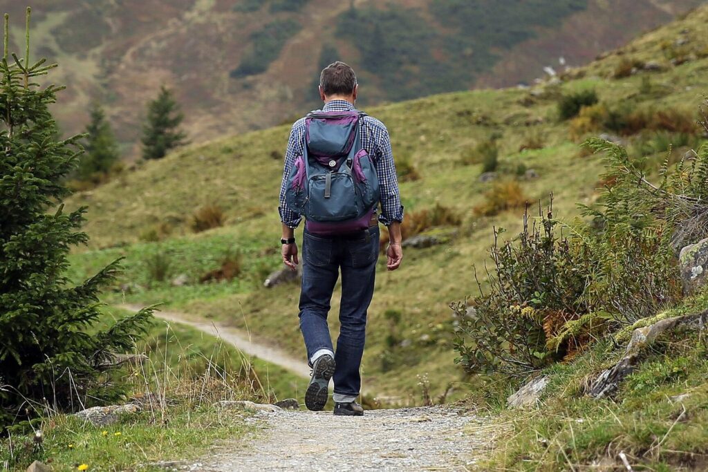 Wanderer mit Tagesrucksack auf einem Bergpfad