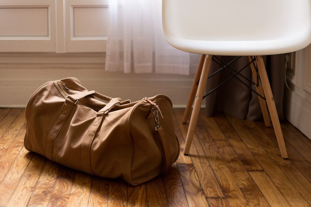 Canvas-Weekender mit Lederdetails auf dem Rücksitz eines Autos